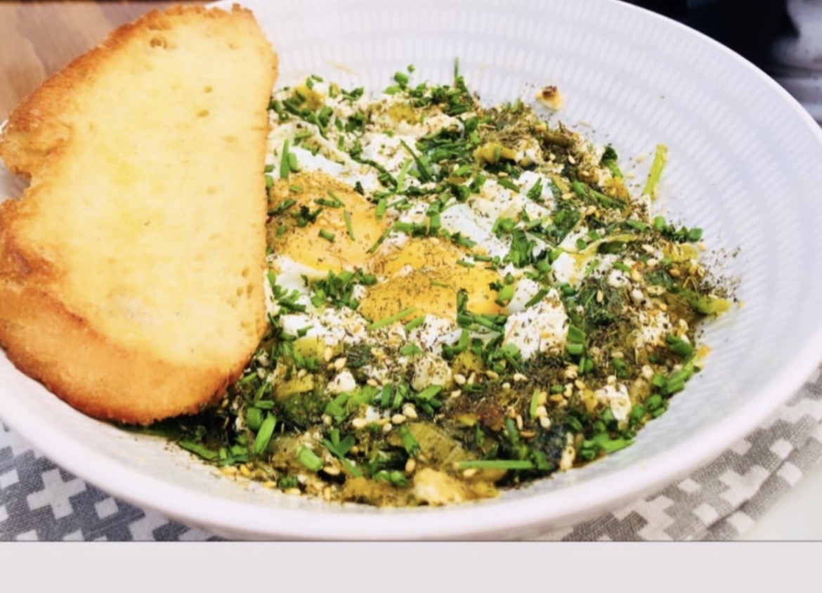 Green shakshuka with baked eggs, herbs and toasted sourdough