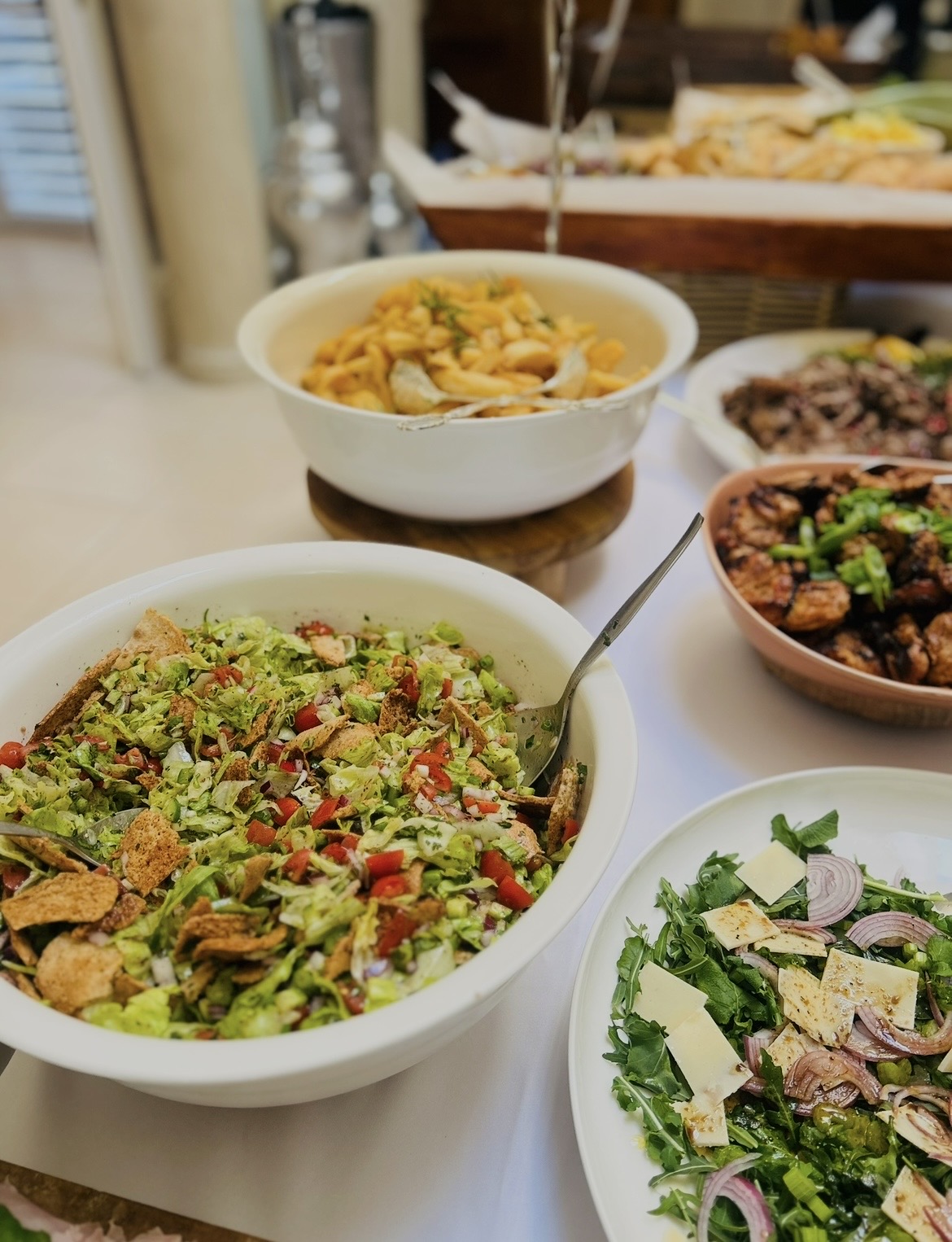 Fattoush and rocket salads on a buffet spread