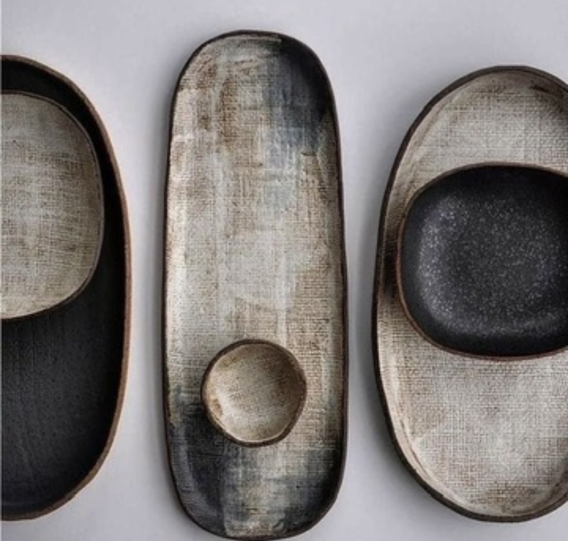 Textured oval serving platters in charcoal and bone