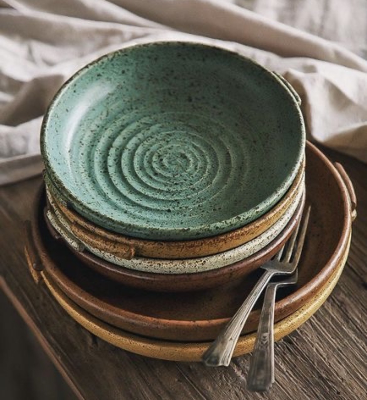 Stacked speckled ceramic bowls in earthy tones