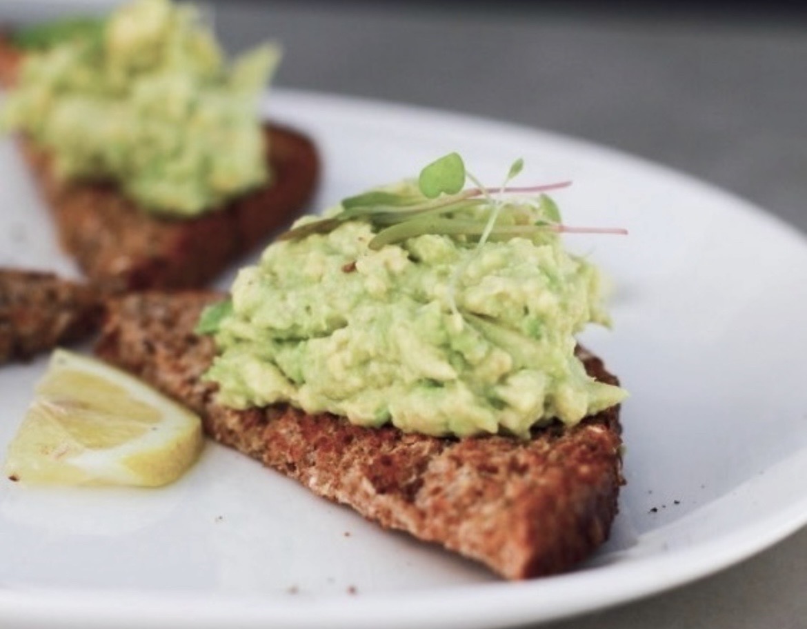Smashed avocado on seeded rye with micro herbs and lemon