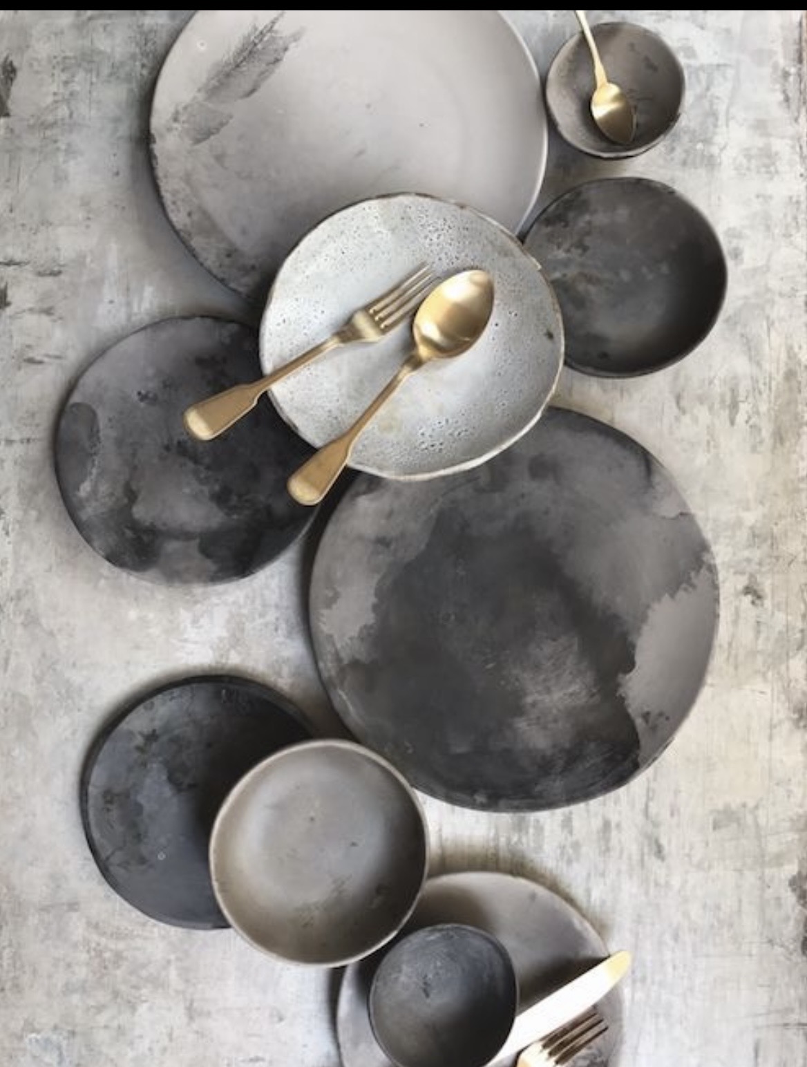Slate and stone plates with brushed brass cutlery