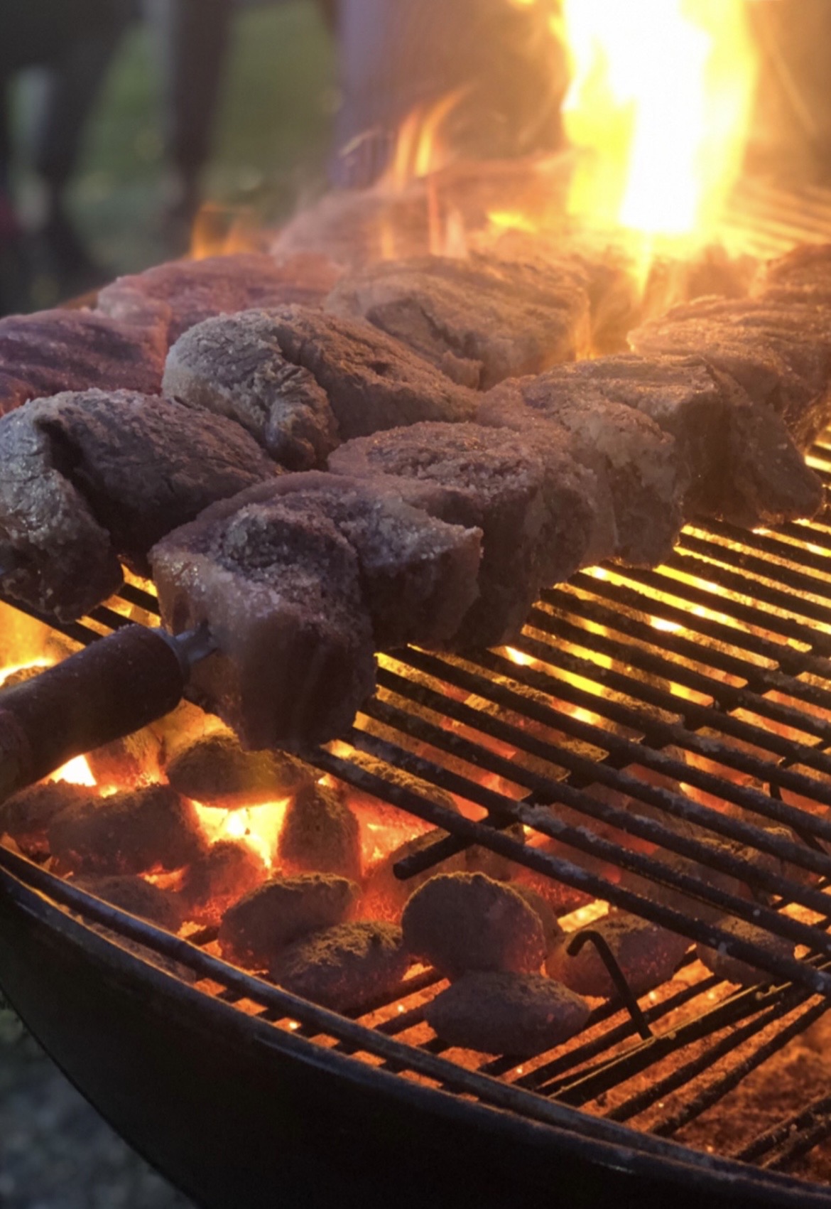 Salted beef espetadas over open flame coals